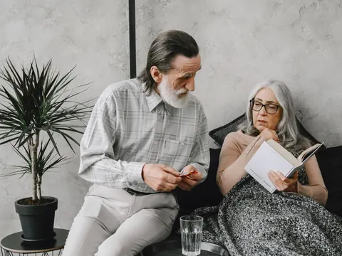 A husband with the medicines beside his resting wife