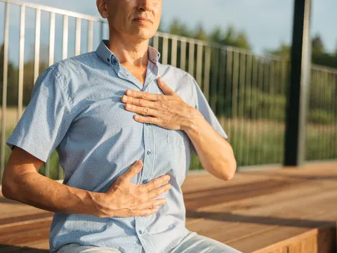 A man with heartburn, hands on his chest and stomach