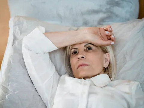 A tired woman lying on her pillows