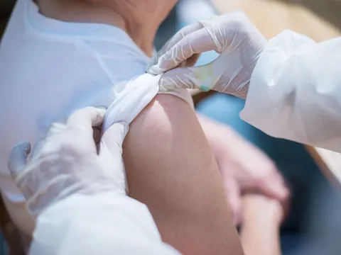 Cotton pressed on the arm after a vaccination