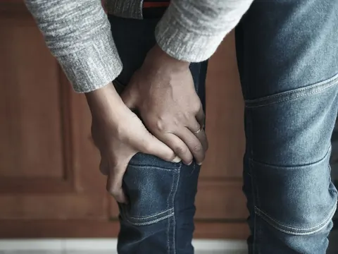 Hands holding a painful knee
