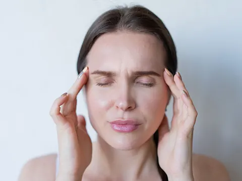 A woman with a migraine holding her temples