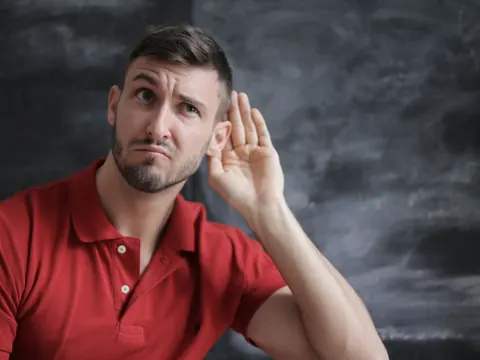A man cupping his ear to hear