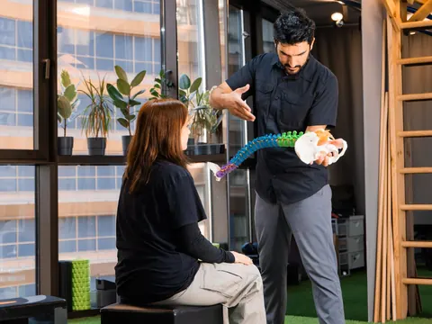 A physiotherapist explaining the spine with a model