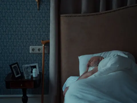 An older man resting in his bed