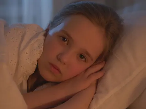 A girl lying awake in bed at night