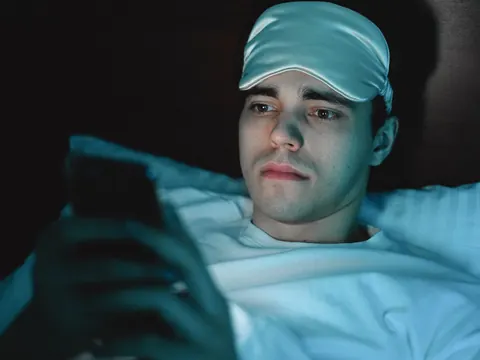 A man lying awake in bed at night