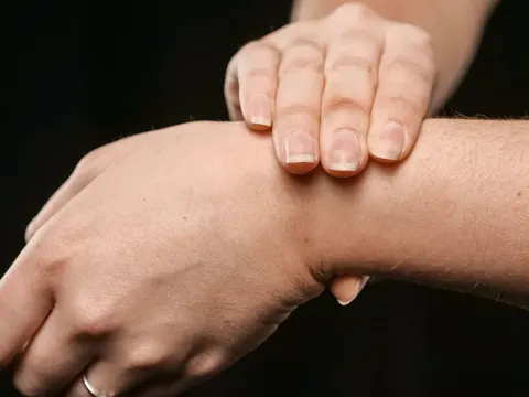 A hand holding a painful wrist