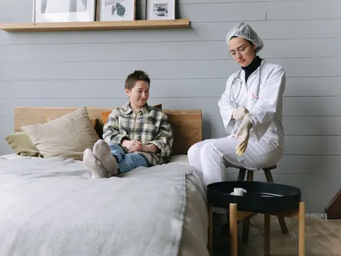 A health worker checking a patient on the bed at home
