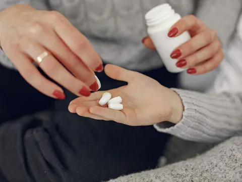 Tablets poured into a palm from the bottle